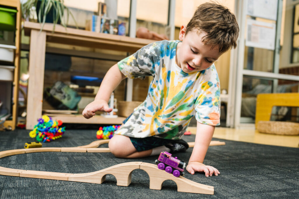 Child playing with train set at Alfred Childcare in Melbourne