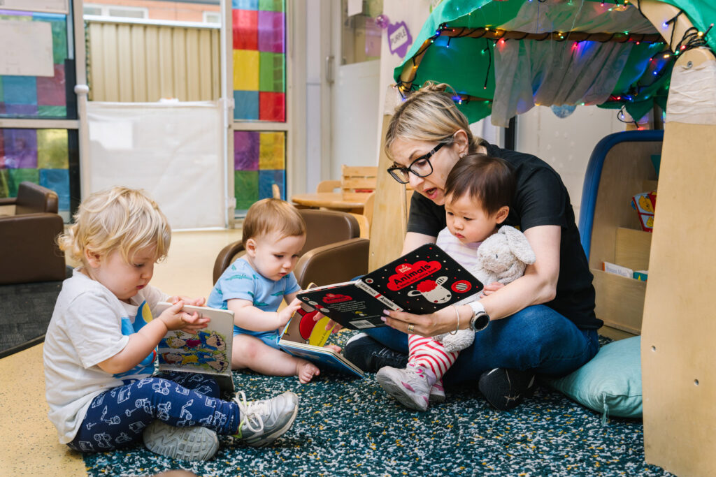 Educator reading with children at Alfred Childcare in Melbourne