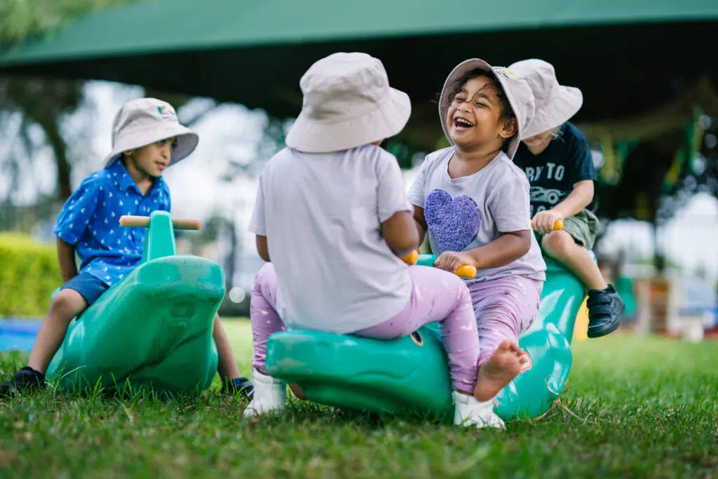 Children playing on a seesaw at KU Briar Cottage childcare