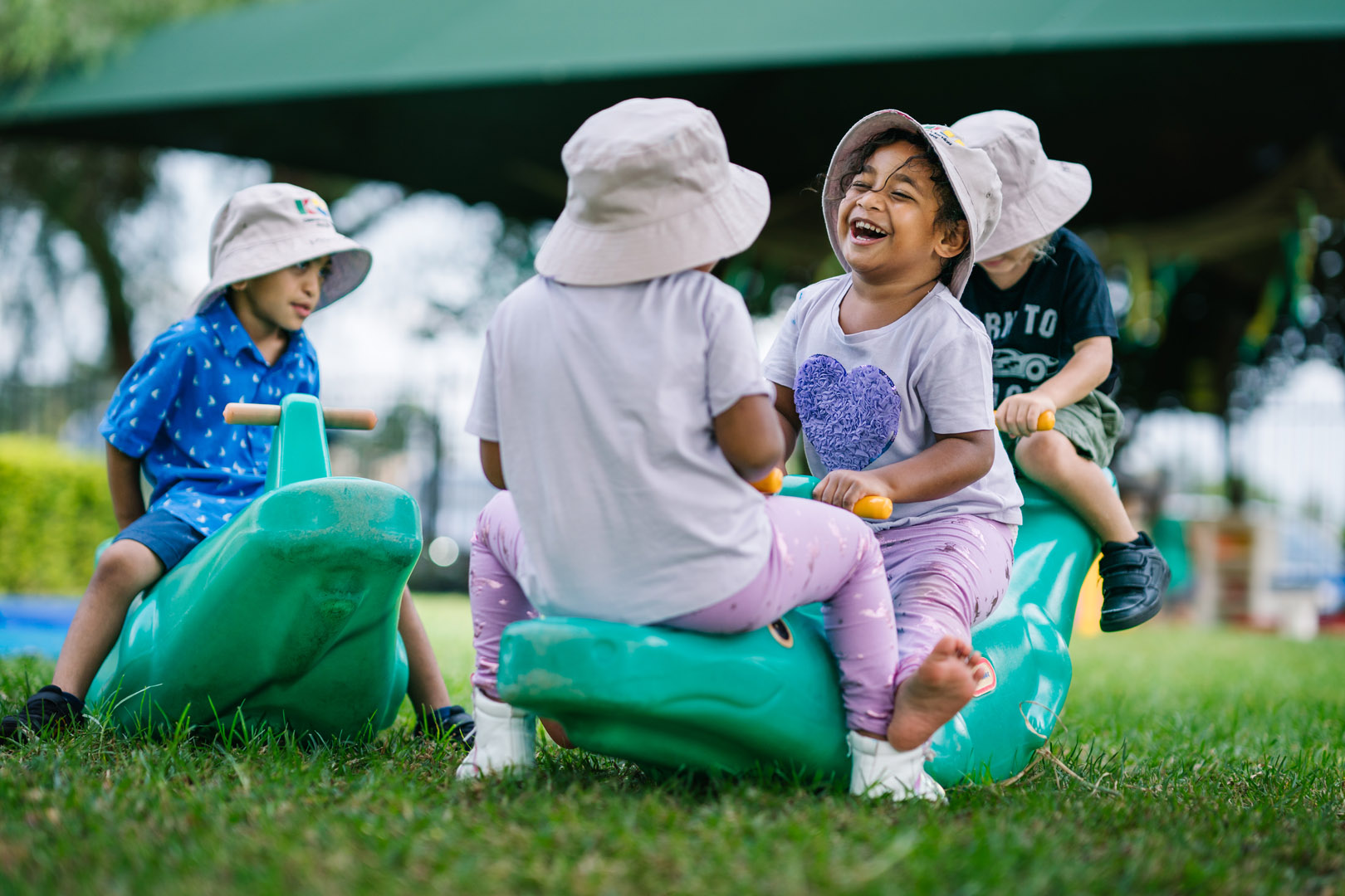 Children playing on a seesaw at KU Briar Cottage childcare