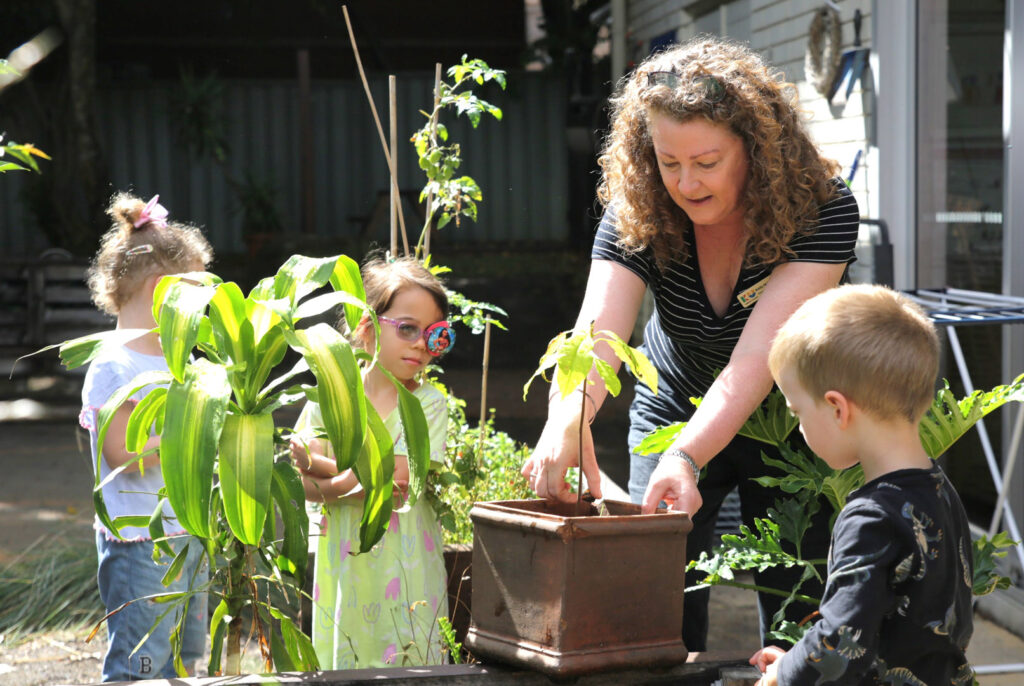 Educator gardening with children at KU Sunbeam childcare in Alexandria