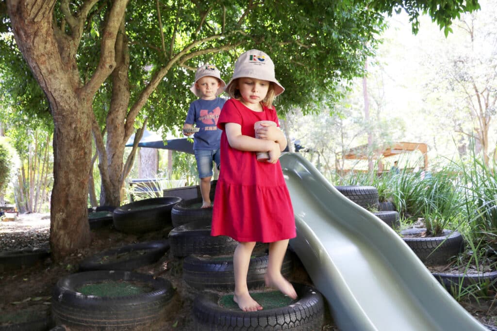 Children playing on the slide at KU Avalon childcare