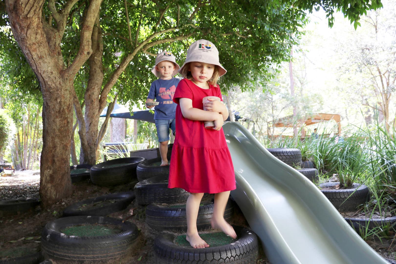 Children playing on the slide at KU Avalon childcare