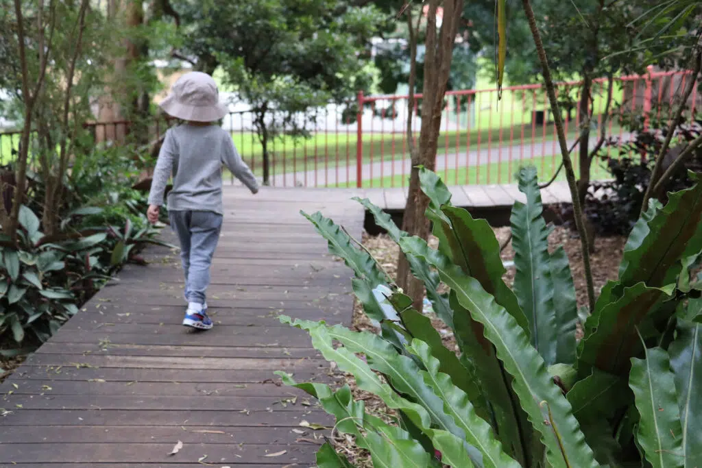 Child walking along a boardwalk at KU Cammeray childcare
