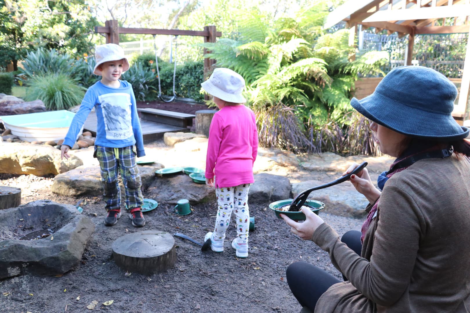 KU Castlecrag childcare educator and children playing outdoors