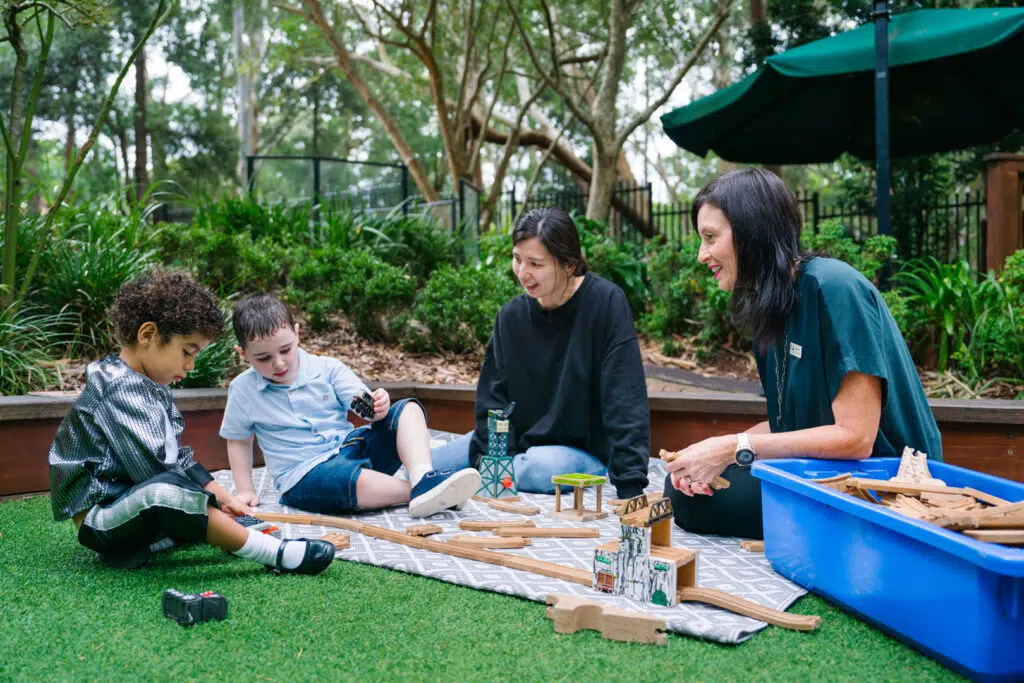 KU Chatswood West childcare educators with children playing outdoors