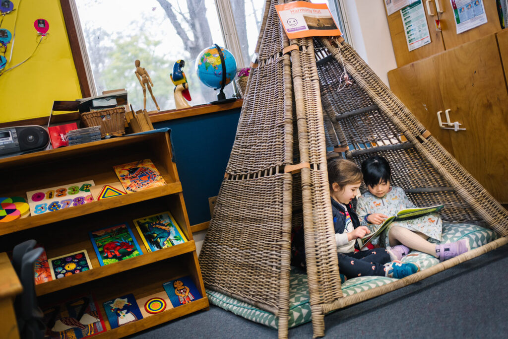Children reading a book at KU Cheltenham Memorial childcare