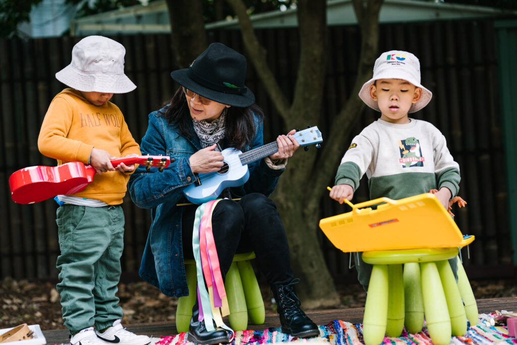 KU Cheltenham Memorial childcare educator playing musical instruments with children