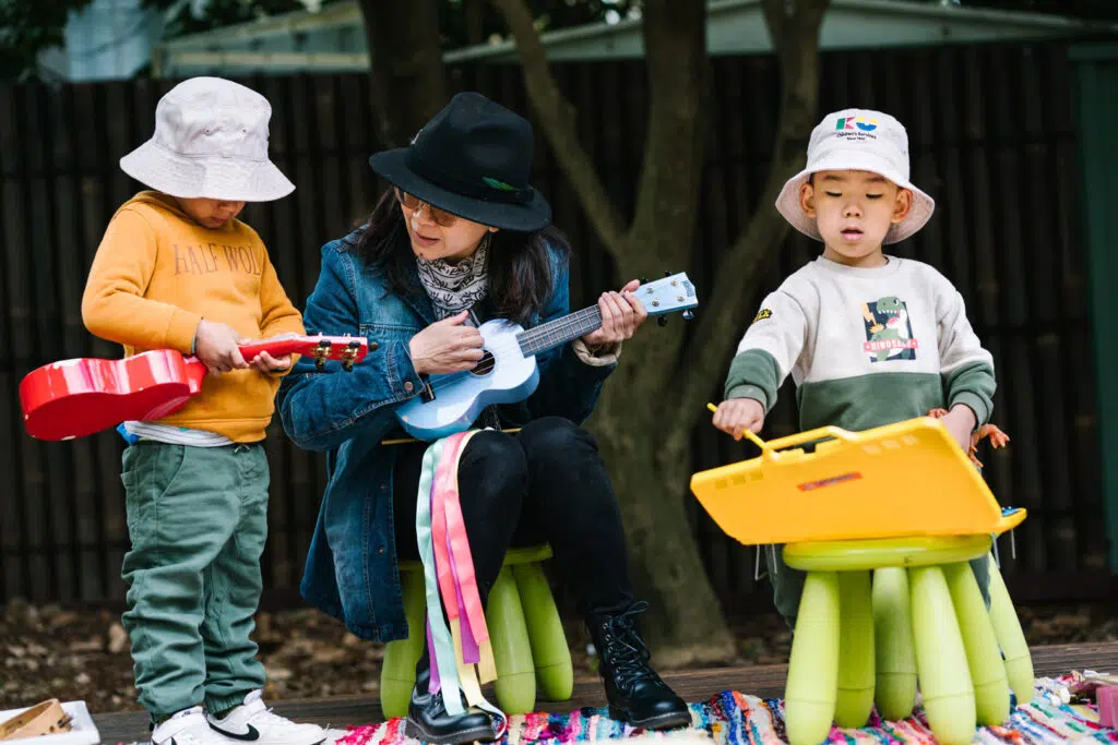 KU Cheltenham Memorial childcare educator playing musical instruments with children