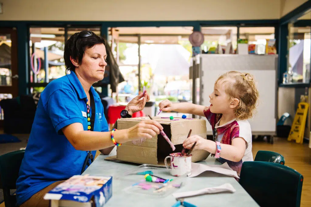 KU Cobbitty childcare educator doing arts and craft with a child