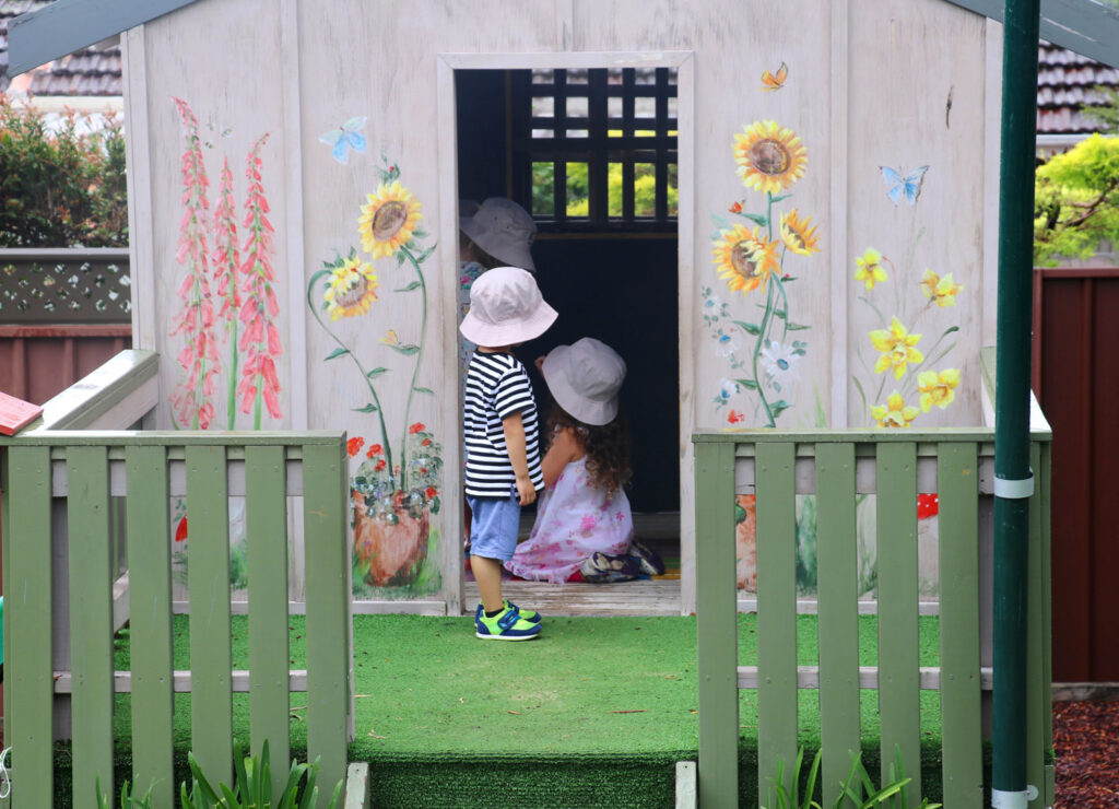 Children playing in the cubby house at KU Figtree childcare