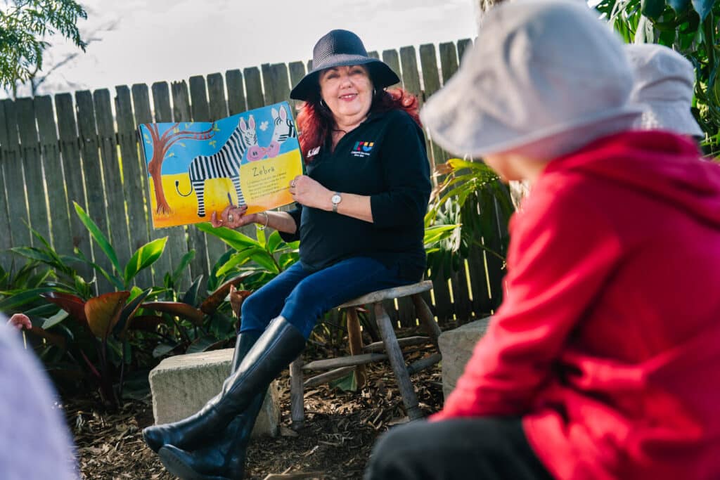 KU Georges Hall childcare educator reading a story to children