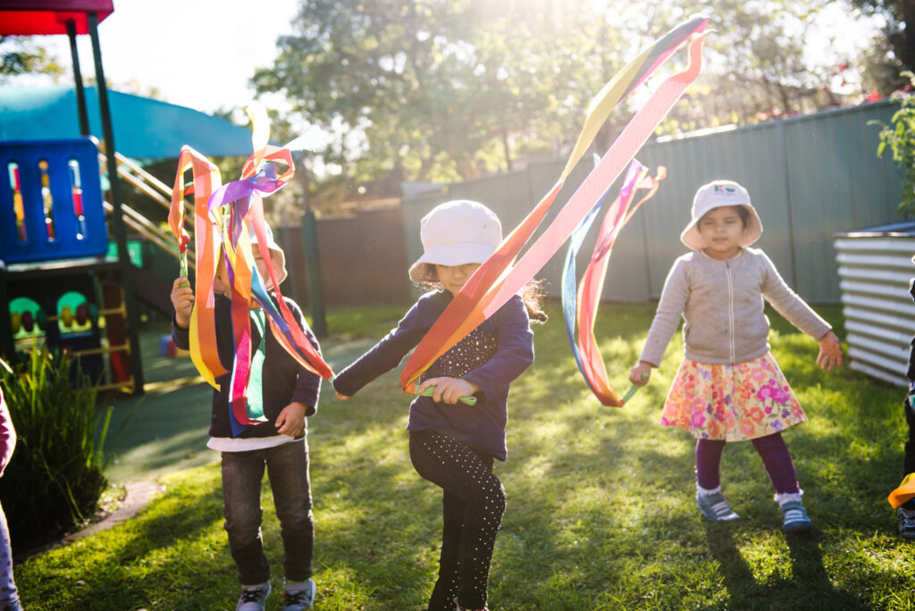 Children playing with ribbons at KU Karingal childcare