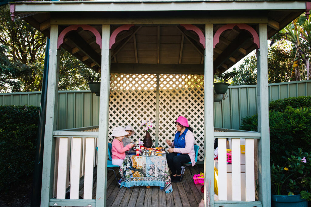 KU Karingal childcare educator and children having an outdoor tea party