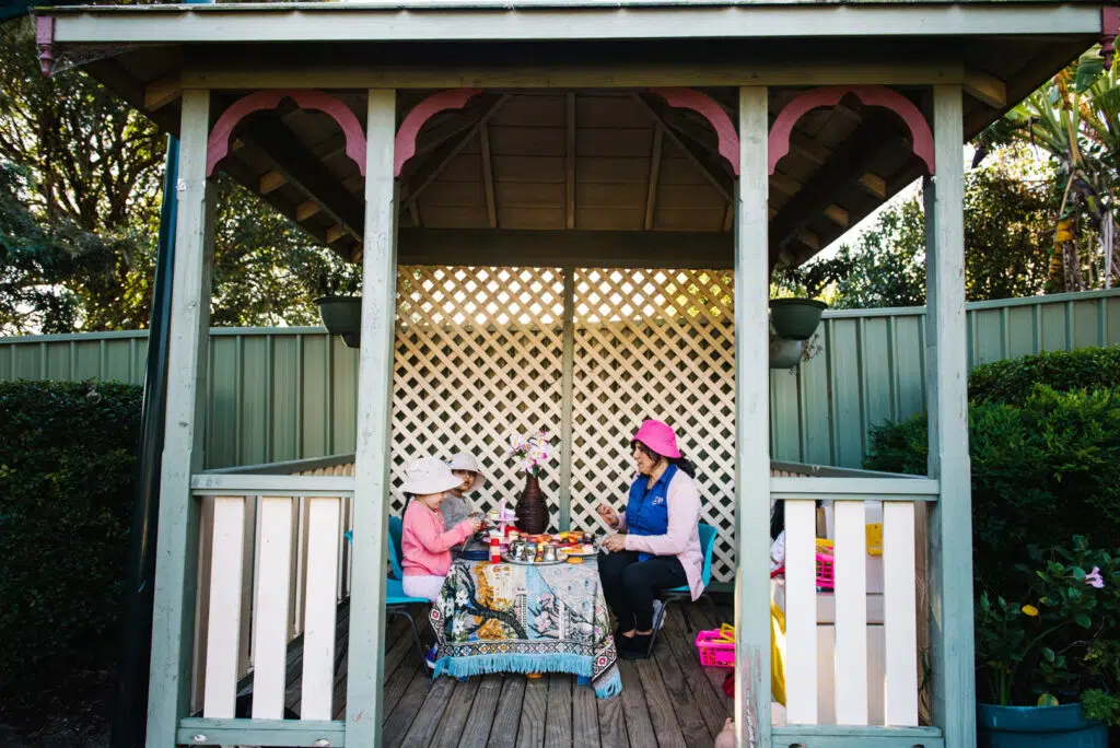 KU Karingal childcare educator and children having an outdoor tea party