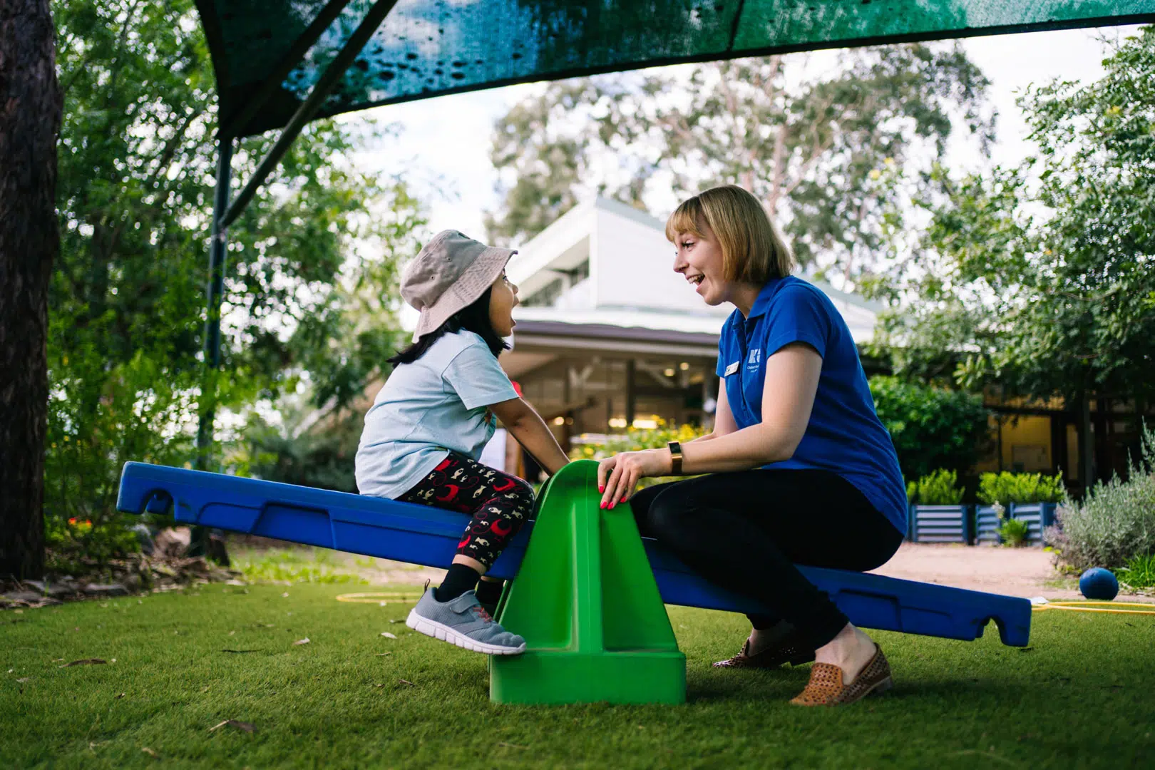 KU Hebersham childcare educator and child on a seesaw