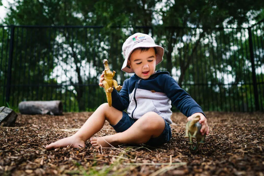 Child playing with dinosaurs at KU Kahibah Road childcare