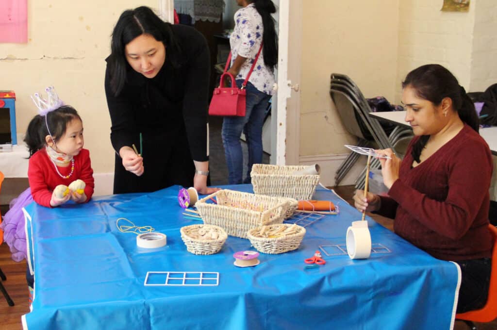 KU IWSP Uniting Church childcare educators doing arts and craft with a child