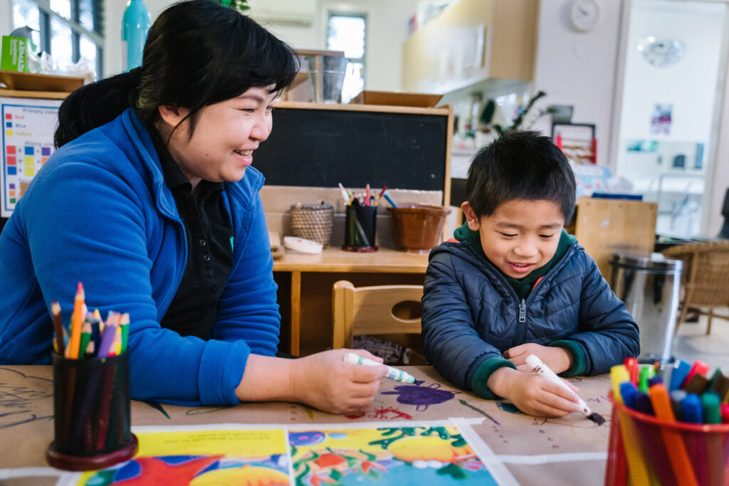 KU Liverpool childcare educator drawing a picture with a child