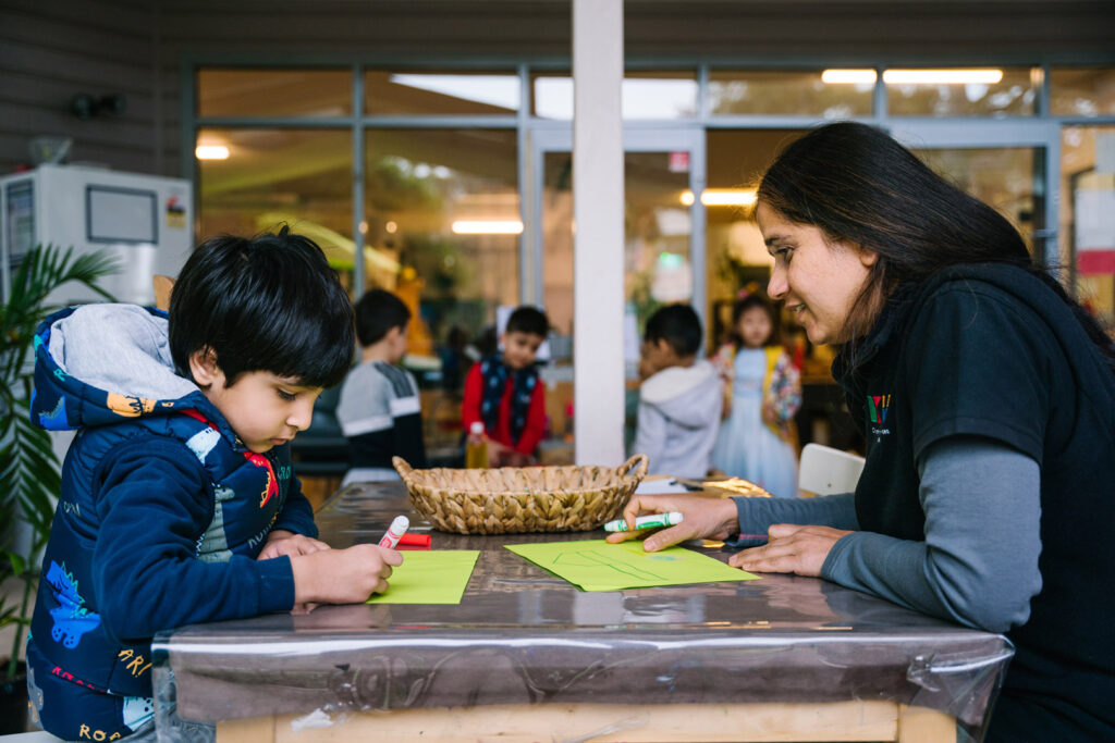 KU Liverpool childcare educator and a child drawing pictures