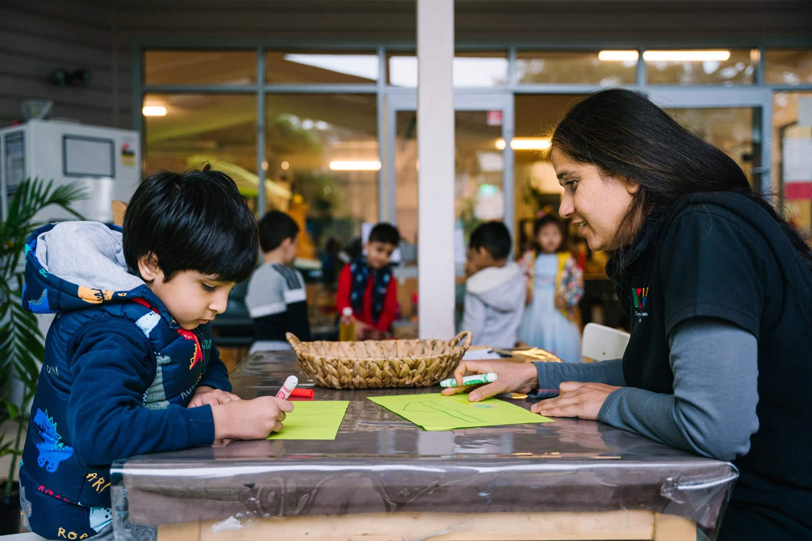KU Liverpool childcare educator and a child drawing pictures