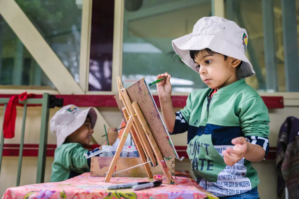 Children painting a picture at KU Macquarie Fields childcare