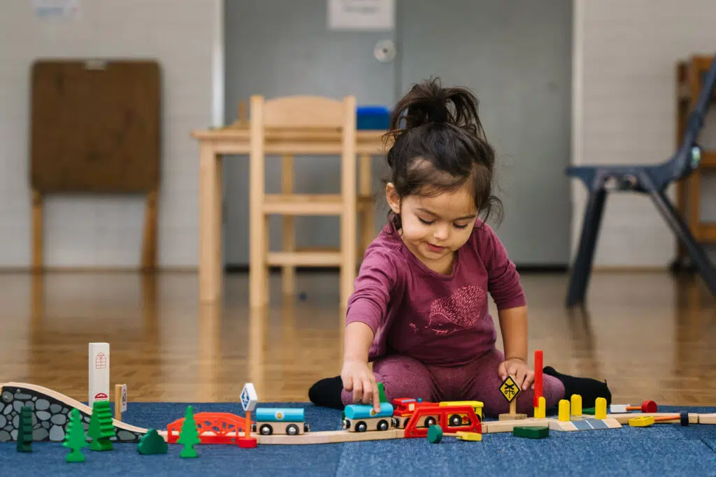 Child playing with a train set at KU NSP Maryland Public School childcare