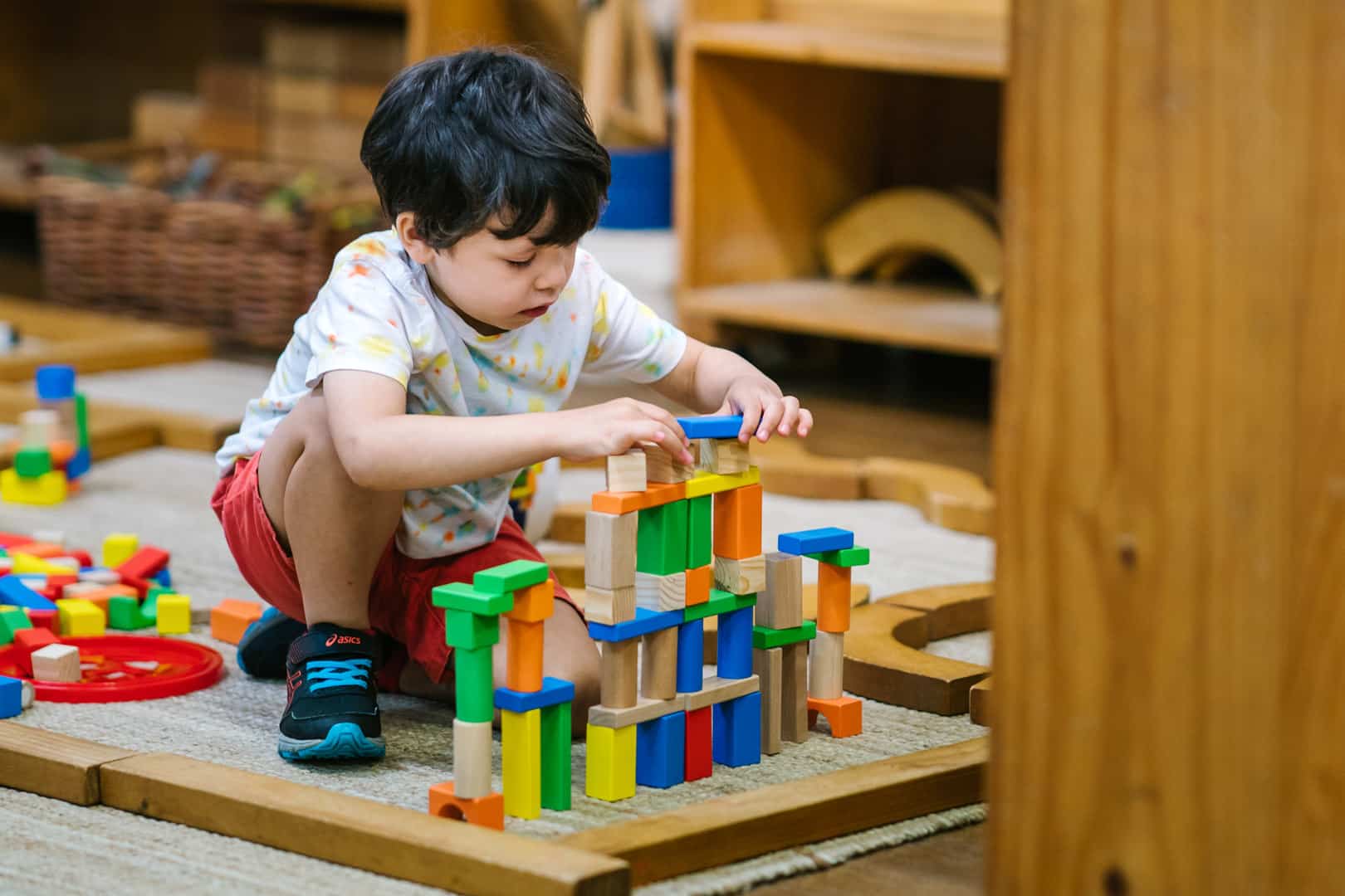 Child building a block tower at KU's The Joey Club childcare