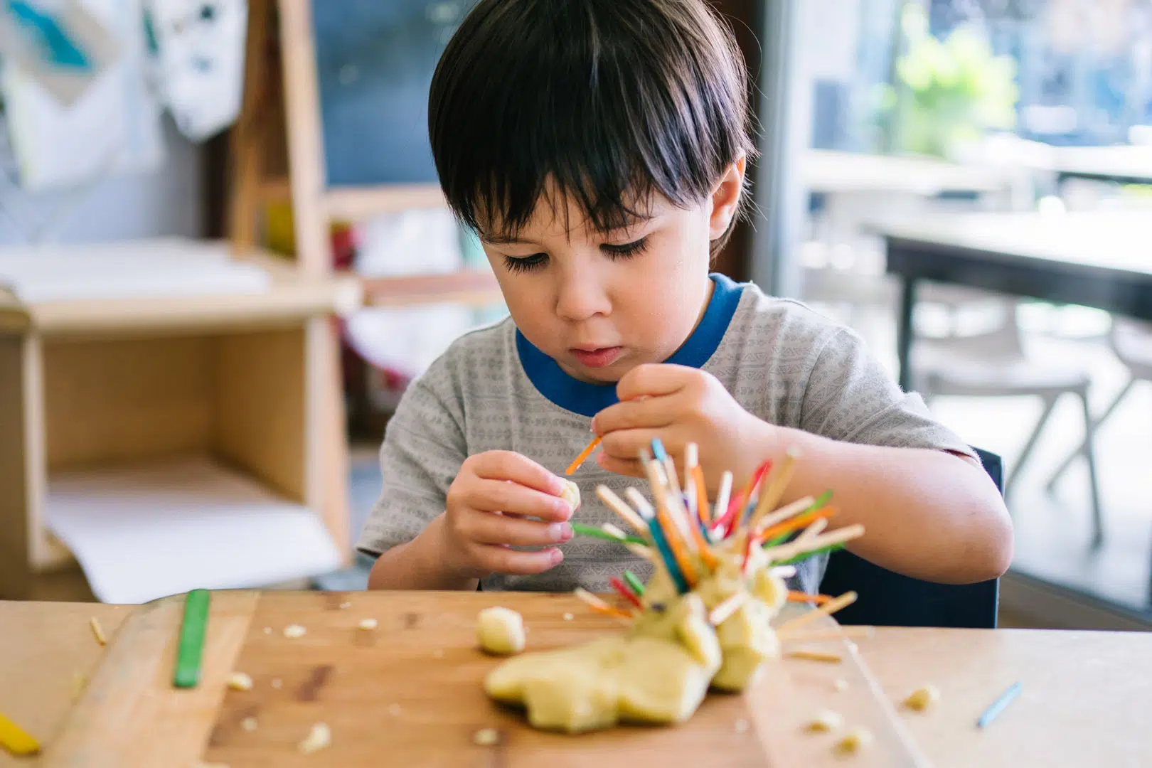 Child playing with playdough at KU's The Joey Club childcare