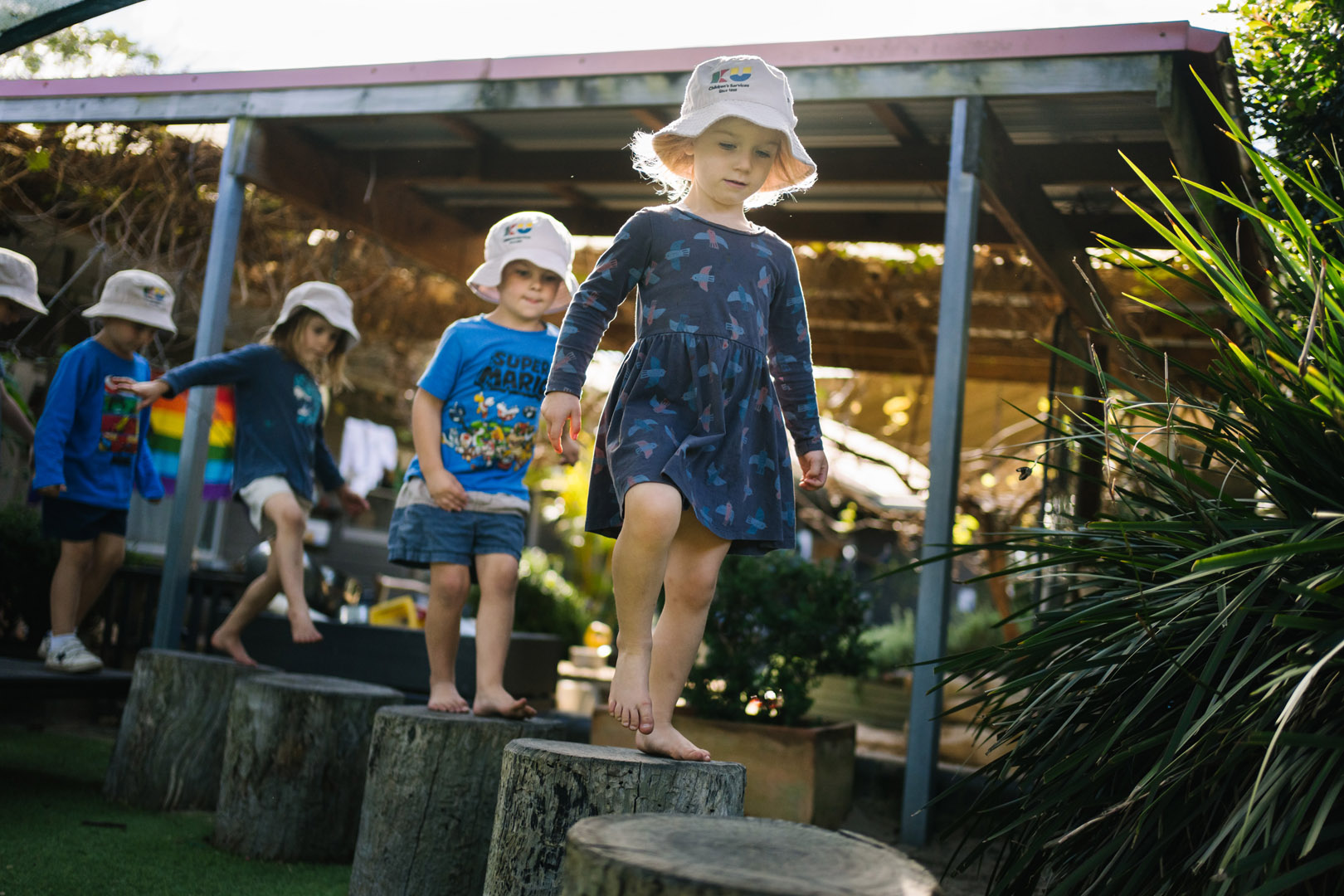 Children walking on logs at KU Mayfield childcare