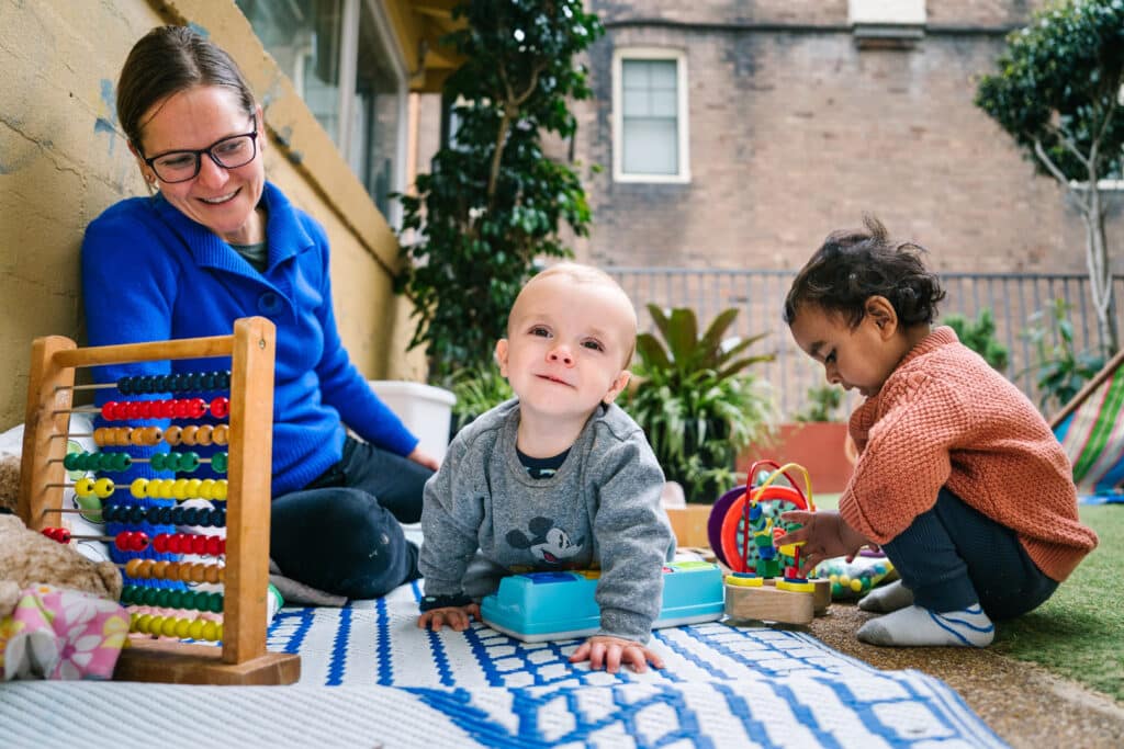 KU Lance childcare educator interacting with children at KU Lance childcare