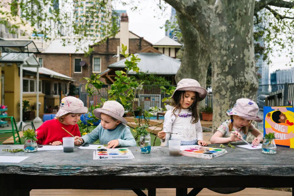 Children painting outdoors at KU Lance childcare