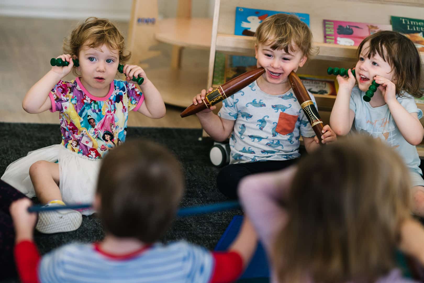 Children playing with aboriginal clapping sticks at KU Lance childcare