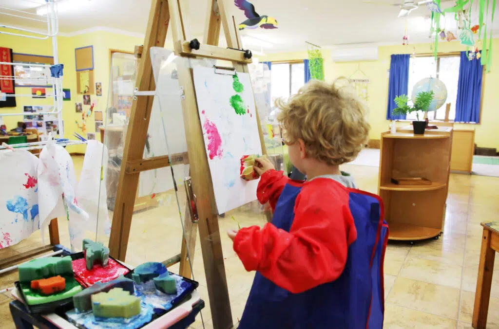 Child painting at KU Moss Vale childcare