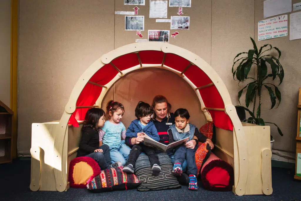 KU Grandstand childcare educator reading a story to children