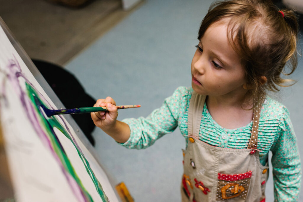 Child painting at KU Ourimbah childcare