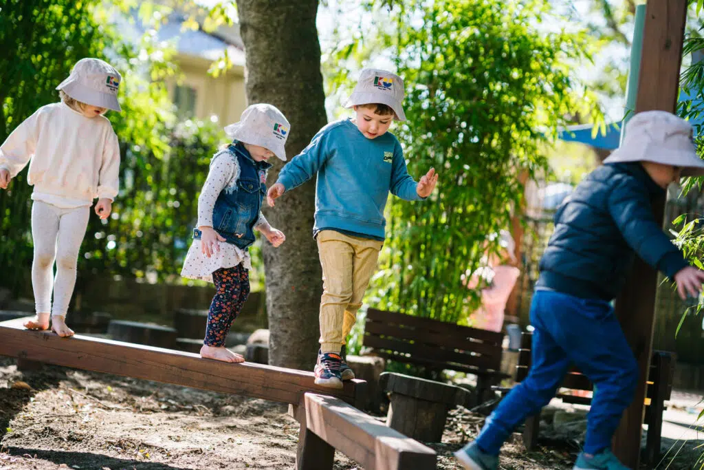 Children walking along a balance beam at KU Peter Pan Paddington childcare
