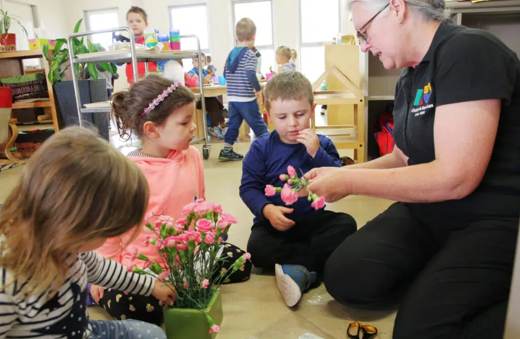 KU Queanbeyan childcare educator showing children some flowers