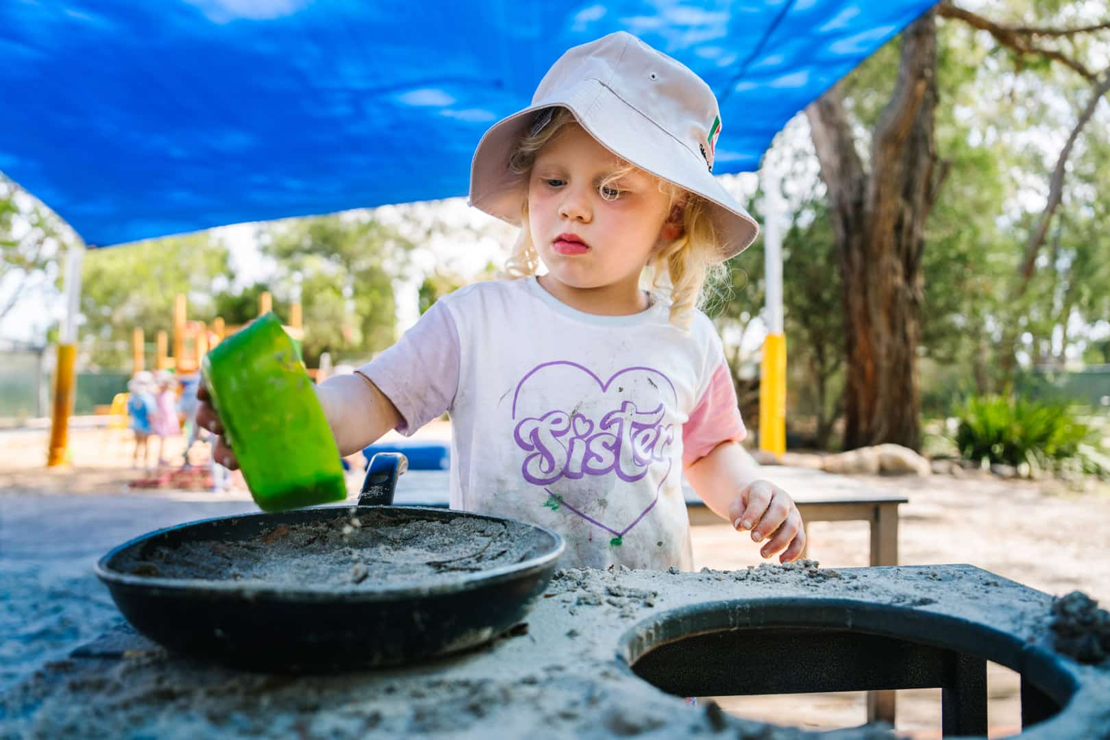 Child playing with sand at KU The Fields Childcare in Rowville