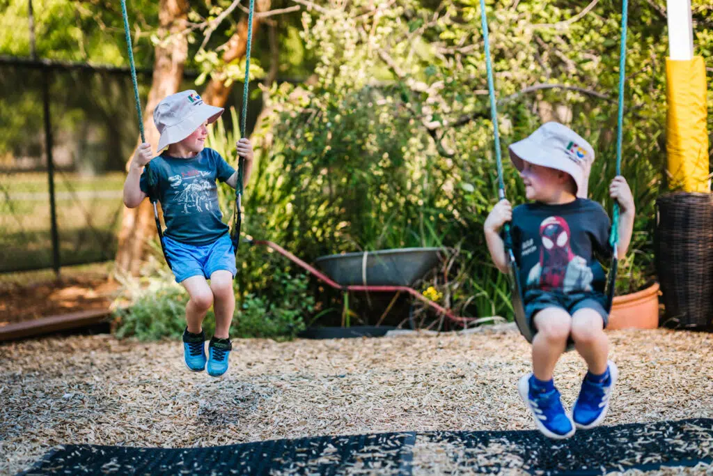 Children playing on swings at KU The Fields childcare in Rowville