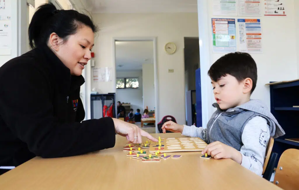KU Henson Street childcare educator doing a puzzle with a child