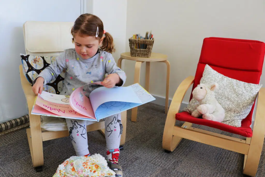 Child reading a book at KU Henson Street childcare
