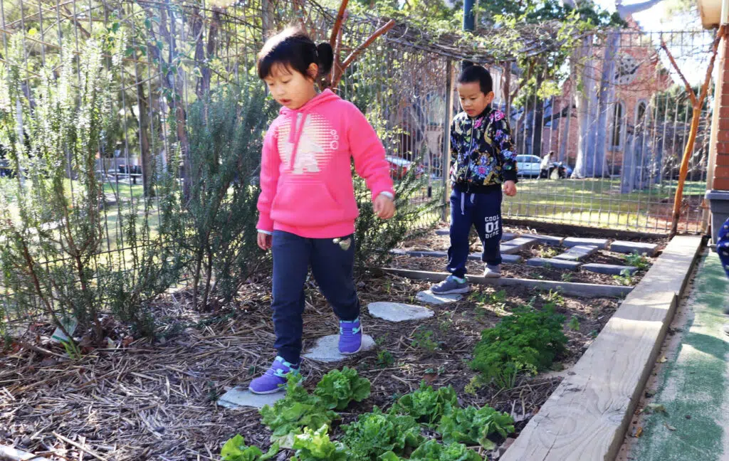Children walking on stepping stones at KU Henson Street childcare