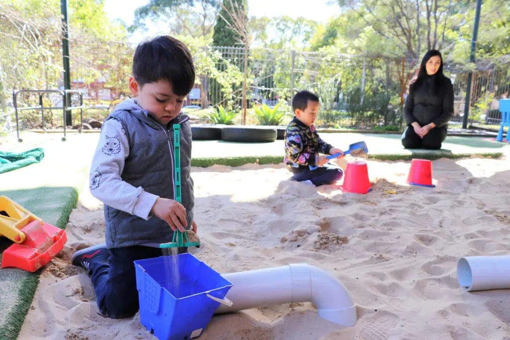 Children building sandcastles at KU Henson Street childcare