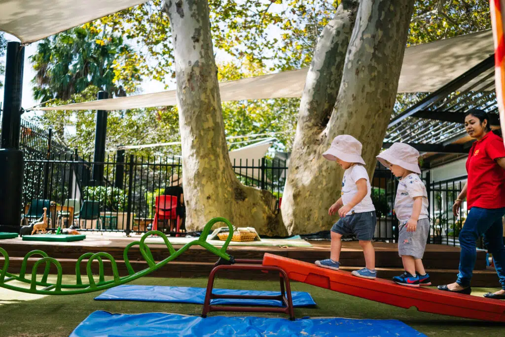 KU Phillip Park childcare educator supervising children on the equipment