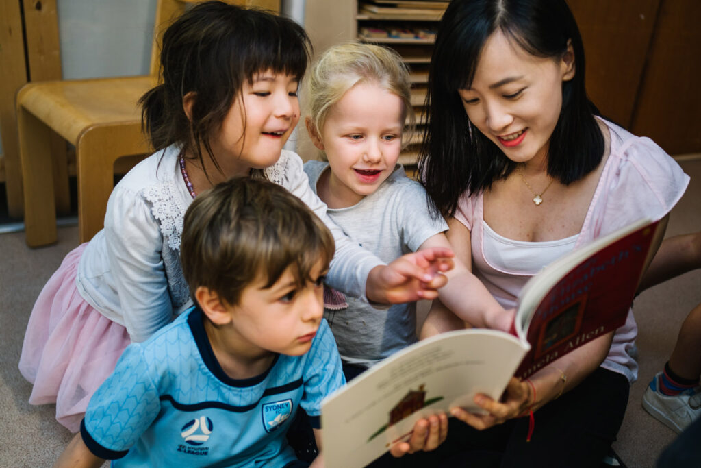KU Bradfield Park childcare educator reading a story to some children