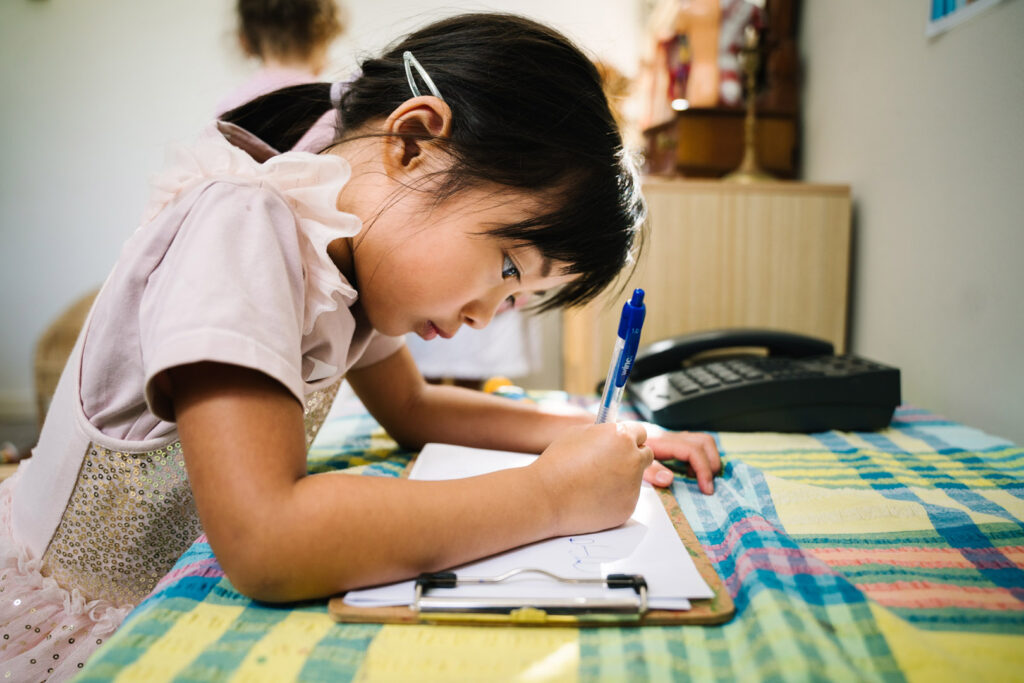 Child writing at KU Carillon childcare