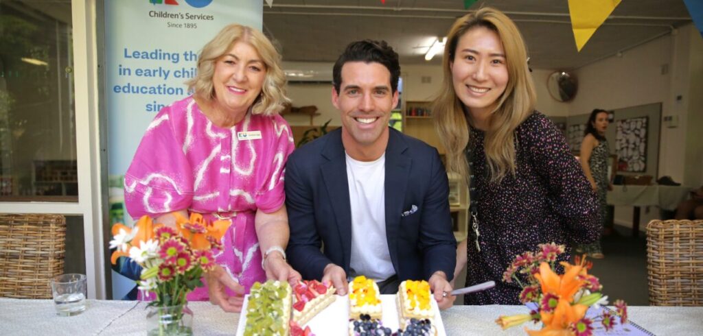 Chris Legg, Zann Maxwell, Sarah Kim, posing for a photograph with KU shaped cake.